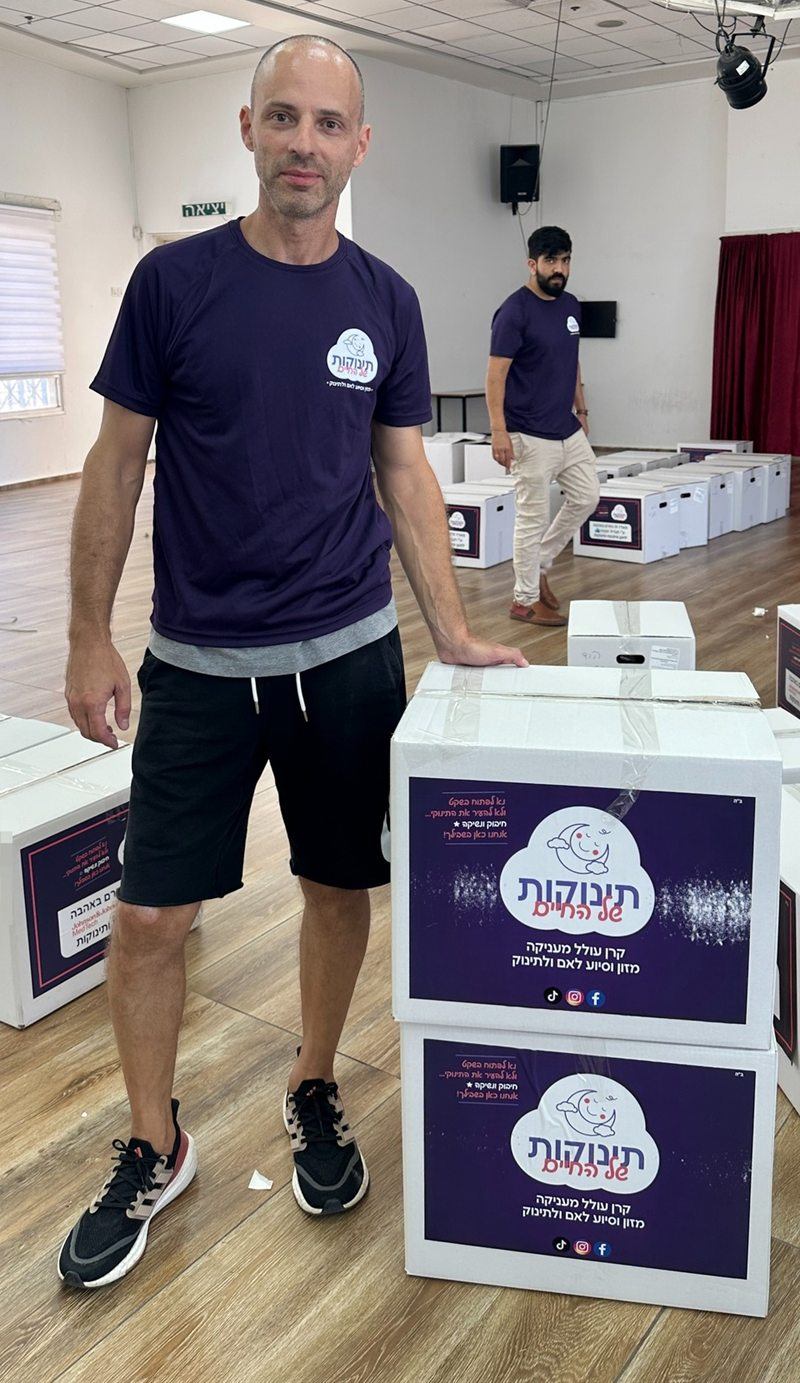 מתנדב ליד מארזים ארוזים ומוכנים לאיסוף